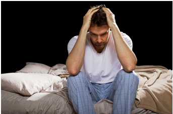 man sitting on bed upset with sleep